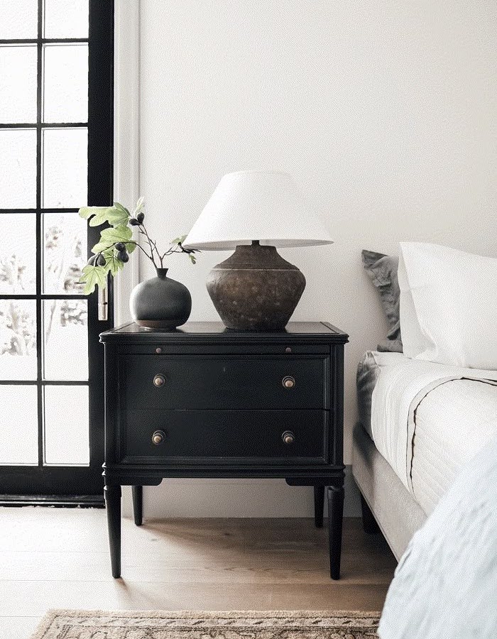 A table lamp sitting on top of a bed pedestal.