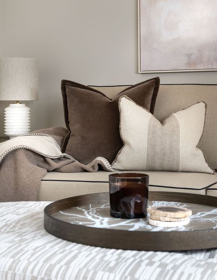 Scatter cushions on a sofa with throw.