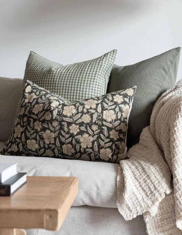 Sofa scatter cushions with a floral pattern and gingham cover.