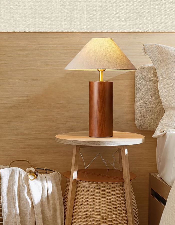 A table lamp sitting on top of a bedside table.