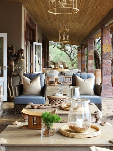 A serene outdoor lounge area at a safari lodge, featuring comfortable seating with plush cushions and natural materials. The space is adorned with stylish lanterns and a wooden coffee table, creating an inviting atmosphere for relaxation. The surrounding greenery enhances the connection to nature, making it a perfect spot for enjoying the outdoors.