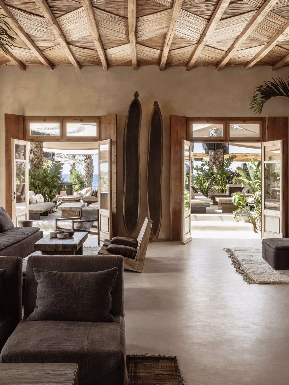 Safari lounge area inspired by East African design, shown through wooden and dark textiles.